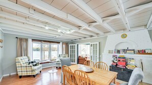 Un comedor con mesa y sillas de madera, un sofá y una estantería llena de libros.