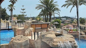 Un'area piscina con una formazione rocciosa e una cascata.