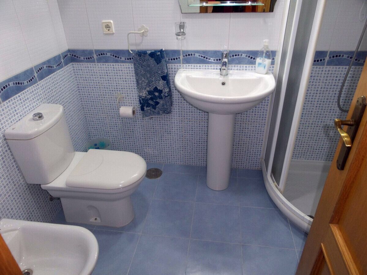 Un baño con inodoro, lavamanos y ducha.