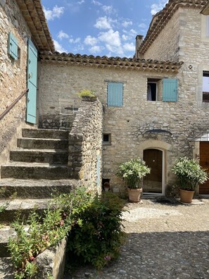 A stone building with a courtyard, a staircase, and potted plants. - Maison DE Hameau - 4 KM Roussillon - 8 KM Gordes (Saint-Saturnin-lès-Apt)