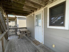 A wooden deck with a bench and a door leading to a covered porch. - Escape to the Beach to Wind & Sand! (HATTERAS)