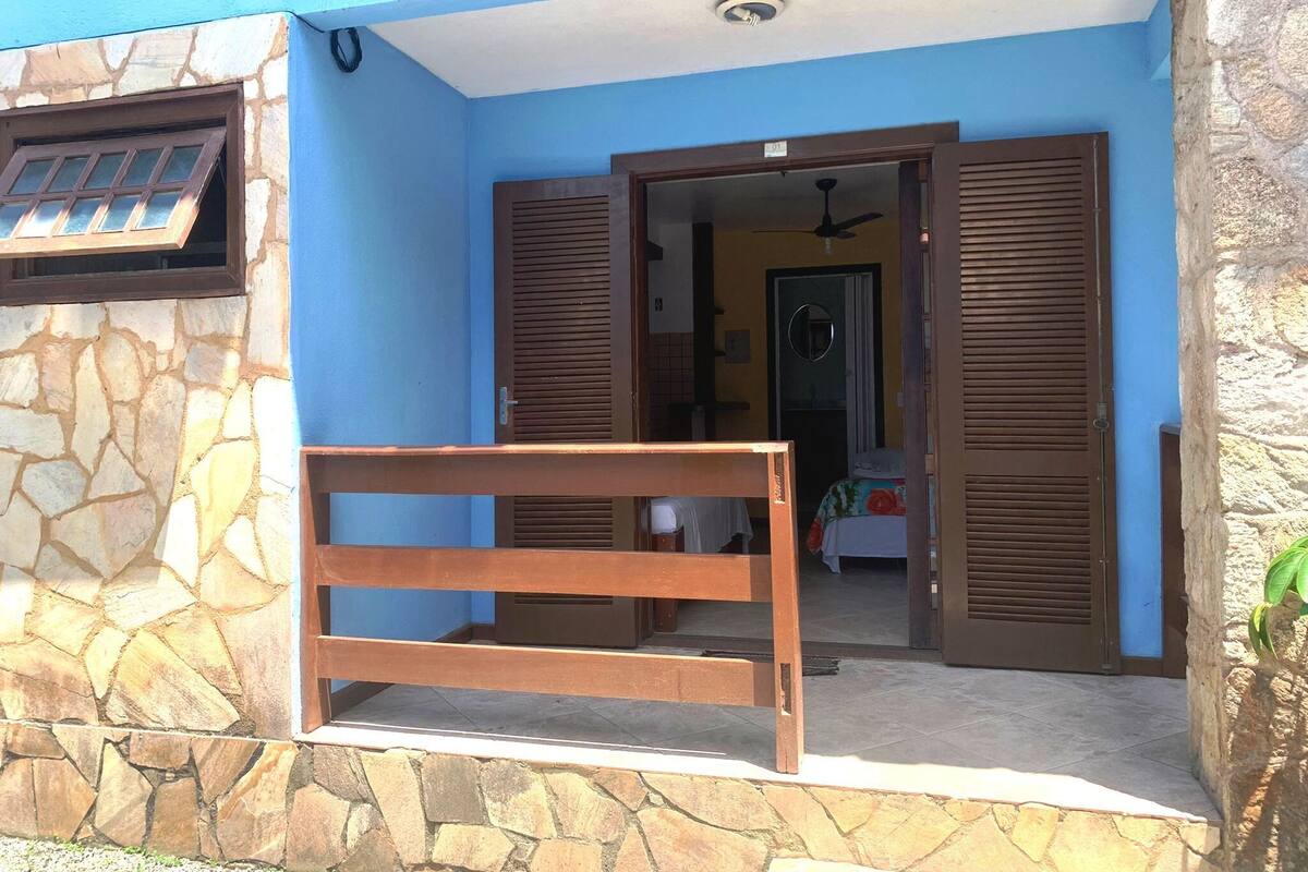 A hotel entrance with a stone facade, a wooden bench, and a door leading inside.