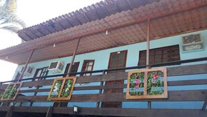 A building with a tiled roof, multiple windows, and air conditioning units. - Pousada Bella Spiaggia (Paraty)