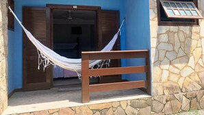 A room with a hammock, wooden shutters, and a stone wall. - Pousada Bella Spiaggia (Paraty)