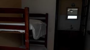 A room with a bunk bed, a single bed, and a small bathroom. - Pousada Bella Spiaggia (Paraty)