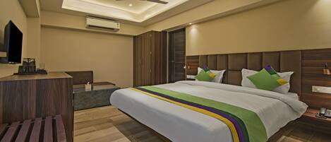 Una habitación de hotel moderna con una cama grande, un escritorio con teléfono y un ventilador de techo.