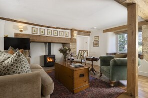 A cozy living room with a fireplace, a sofa, a chair, and a television.