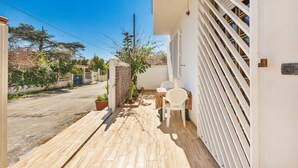 A narrow paved pathway leading to a white building with a covered outdoor seating area. - 3304 Terra del Salento - Mono Costa by Barbarhouse (Porto Cesareo)