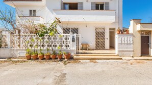 A two-story white building with a balcony, potted plants, and a small table outside. - 3304 Terra del Salento - Mono Costa by Barbarhouse (Porto Cesareo)