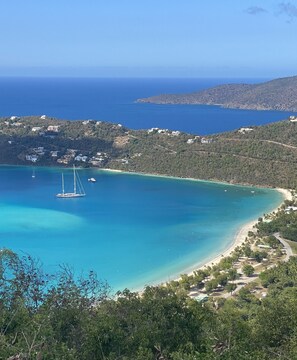 A coastal landscape with a clear blue sea, a small sailboat, and a beach with sparse vegetation. - Unplug & Unwind, Unplug & Unwind St. Thomas Style (Northside)