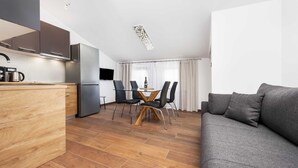 A modern apartment with a kitchen, dining area, and living room.
