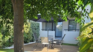 Un patio con sillones, una mesa y un espacio de estar techado.