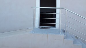 A building entrance with a metal staircase and a door.