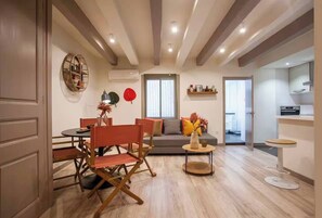 Un salon moderne comprenant un coin repas, un canapé et un espace cuisine.