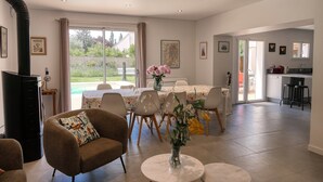 Un espace de vie spacieux comprenant une table à manger, des sièges confortables et une vue sur l’extérieur.