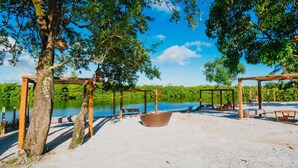 A beach area with wooden structures, a large wicker basket, and a sandy ground. - VILAGOA POUSADA (Coqueiro Seco)