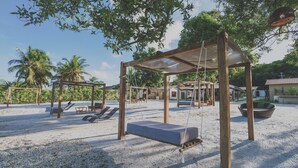 A beach with a swing set and lounge chairs. - VILAGOA POUSADA (Coqueiro Seco)