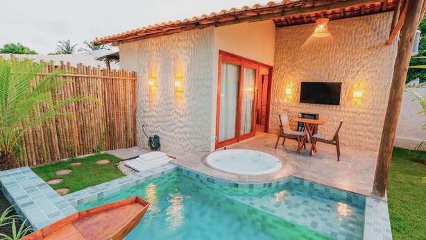 A private pool area with a hot tub, a wooden deck, and a seating area with a table and chairs. - VILAGOA POUSADA (Coqueiro Seco)