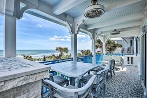 Enjoy ocean views from this outdoor seating area with a table and chairs.