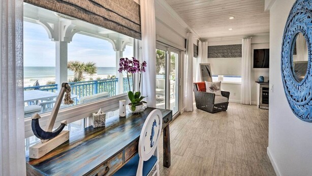 Une pièce donnant sur la côte, avec vue sur la mer, comprenant un bureau en bois, une chaise et un miroir décoratif.