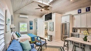 Un espacio habitable compacto con kitchenette, comedor y un dormitorio con cama y zona de estar.