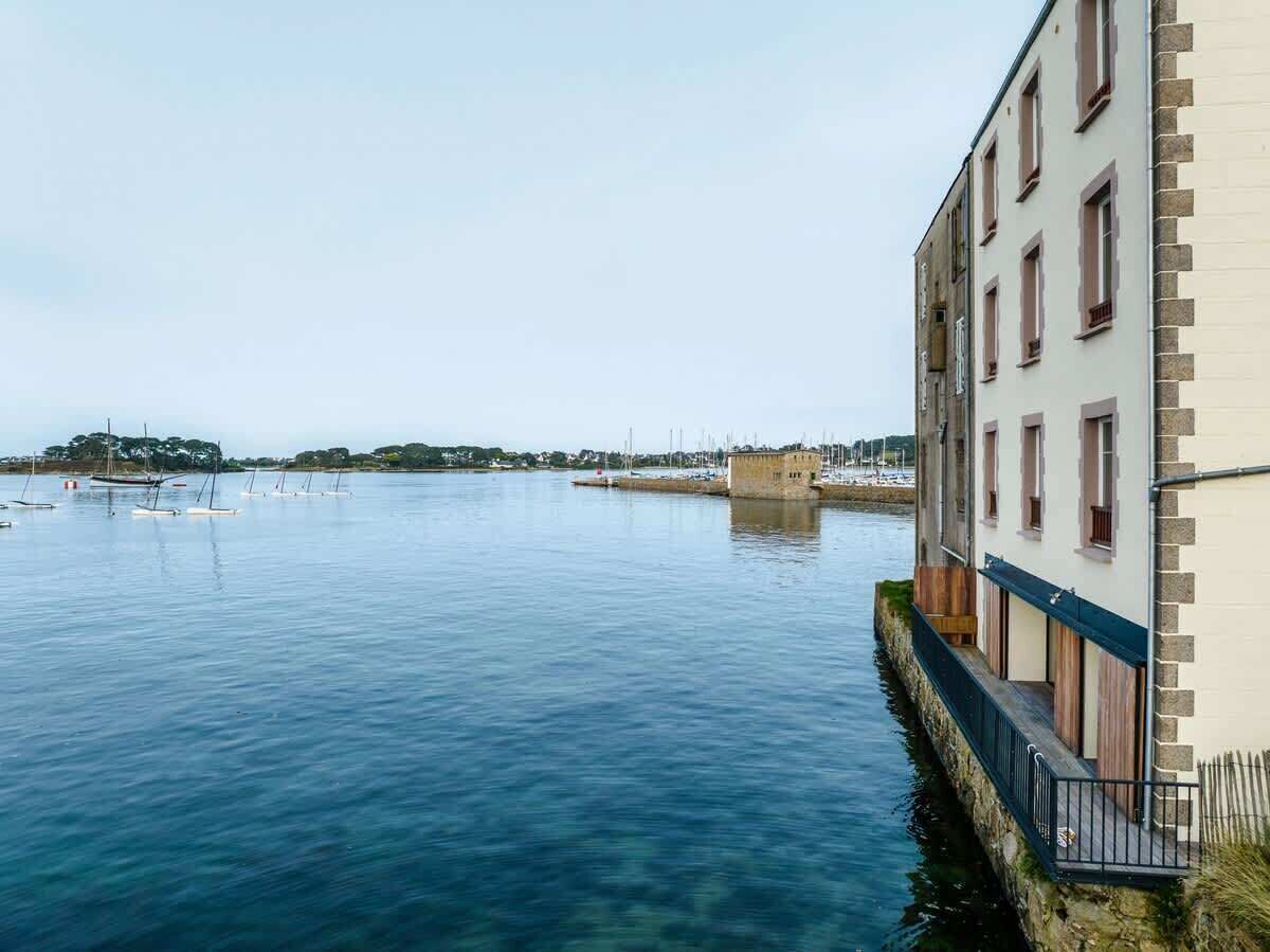 A waterfront building with a clear view of the water and distant land.