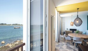 A modern dining area with a view of the sea and boats.