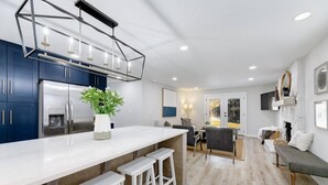 A modern kitchen with a white countertop, stainless steel appliances, and a geometric light fixture. - Updated Eagle Home | Hot Tub + Walk to Downtown (Eagle)
