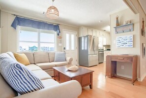 Relax in this spacious living area with a comfortable sofa, coffee table, and kitchenette.