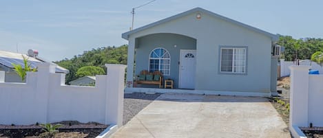 A small, single-story building with a covered porch and a door.