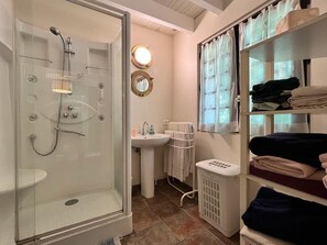 Douche, baignoire à remous, séchoir à cheveux, serviettes fournies