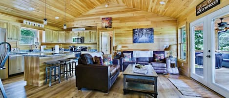 Interior espacioso de una cabaña de madera con cocina, comedor y sala de estar.