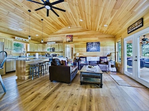 A spacious wooden cabin interior with a kitchen, dining area, and living room. - Pet-Friendly Cabin w/Mountain Views, Large Deck, Hot Tub & Fire Pit (Murphy)