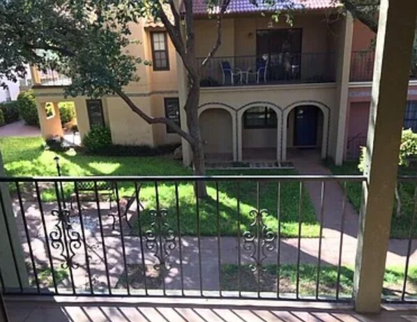 A two-story building with a balcony and a small garden area. - Ideal townhouse for relaxation (Midland)