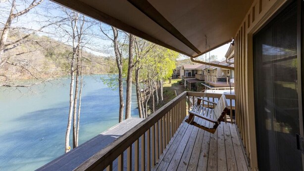 A wooden deck with a view of a lake and trees. - Golf & Lake View Retreat - Rumbling Bald Resort Amenities, Sleeps 6 (Lake Lure)