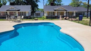 A swimming pool with a curved edge, surrounded by a concrete deck. - AV    Bungalows   #2 (Arcadia)