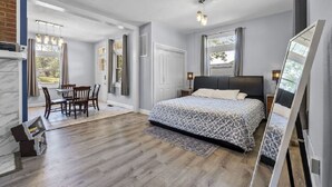 Une chambre à coucher avec un lit, un bureau et une chaise. Il y a une fenêtre et une porte.