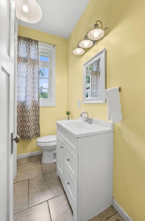 A bathroom with a white sink, a mirror, and a toilet.