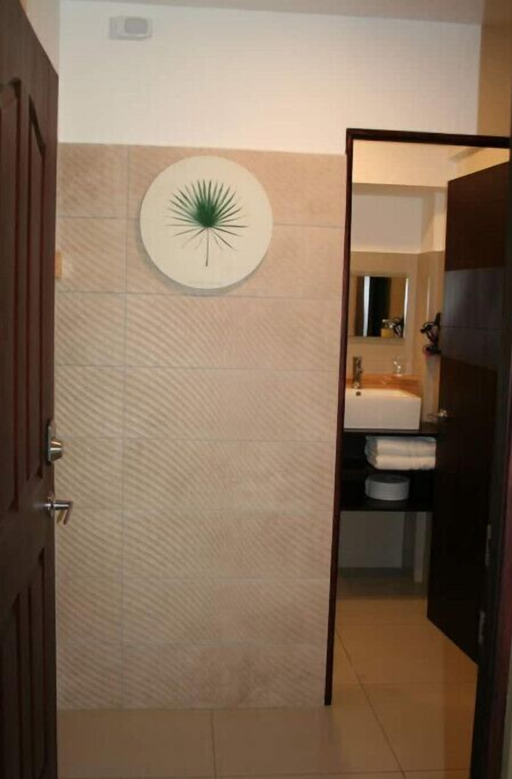 Une salle de bain avec un miroir rond, un lavabo et des toilettes.