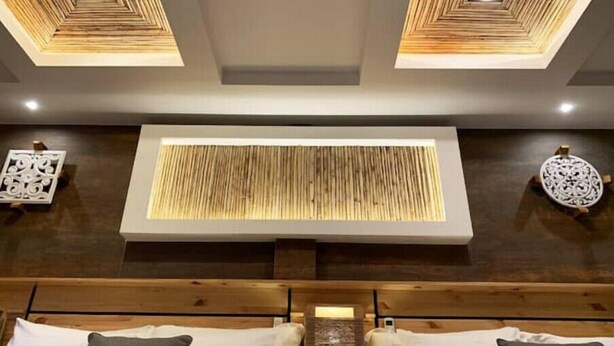 A modern bedroom with a wooden headboard, a central light panel, and two decorative wall pieces. - ARANJUEZ LOFTS - Tree Loft #6 (Santa Ana)