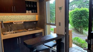 A compact kitchen with dark cabinets, a tiled backsplash, and a wooden countertop. - ARANJUEZ LOFTS - Tree Loft #6 (Santa Ana)