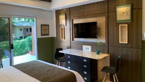 A modern bedroom with a large bed, a desk, and a TV mounted on the wall. - ARANJUEZ LOFTS - Maya Loft #8 (Santa Ana)