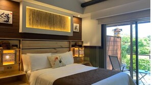 Una habitación de hotel moderna con una cama grande, cabecera de madera, mesita de noche con lámpara y vistas al exterior a través de un ventanal corredero.