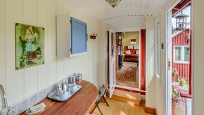 Ein schmaler Korridor mit Holzboden, einem blauen Schrank und einem Gemälde an der Wand.