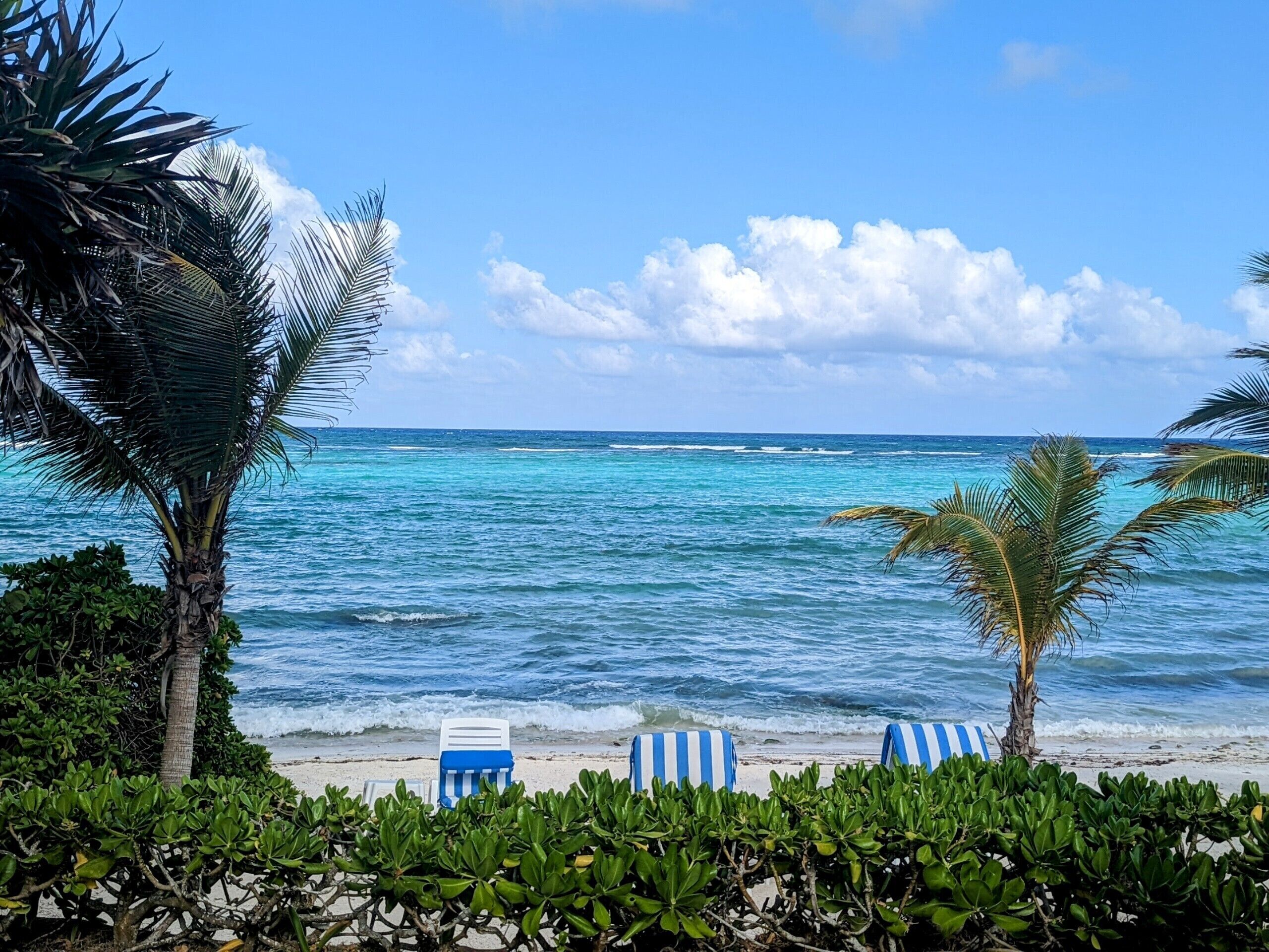 Rannalla, aurinkotuoleja, rantapyyhkeitä