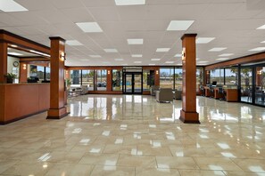 A spacious lobby with a tiled floor, wooden pillars, and a reception desk. - Quality Inn Yemassee - Point South I-95 (Yemassee)