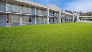 A multi-story hotel with a flat roof, large windows, and a well-maintained lawn in front. - Quality Inn Yemassee - Point South I-95 (Yemassee)