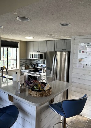 Enjoy cooking in this well-equipped kitchen with a central island, sink, and stainless steel appliances.