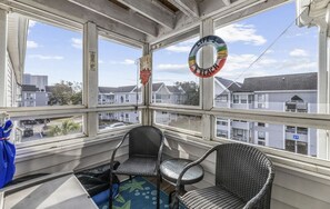 Enjoy a peaceful view of the city from this corner room, featuring two comfortable chairs and a small table.