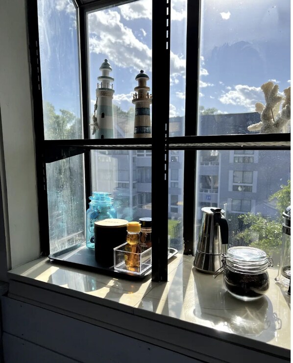 Enjoy breathtaking views of the ocean from this room, featuring a window sill with a beautiful view of two lighthouses in the distance.